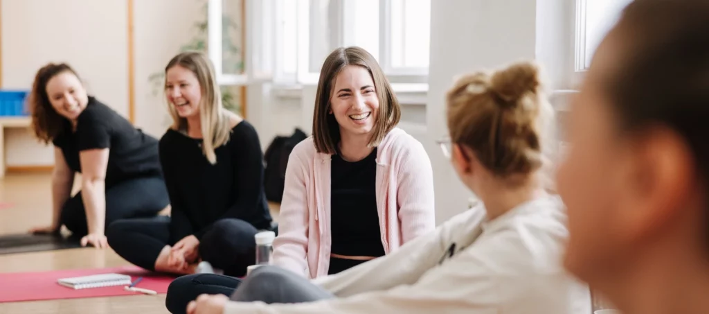 Yogalehrer-Ausbildung finden - mehrere lachende Personen beim Yogaunterricht