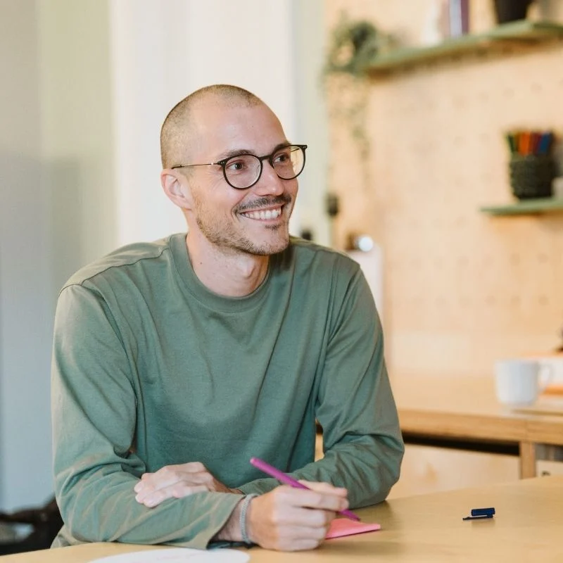 Mann lächelt bei der Stress Management Trainer*in Ausbildung